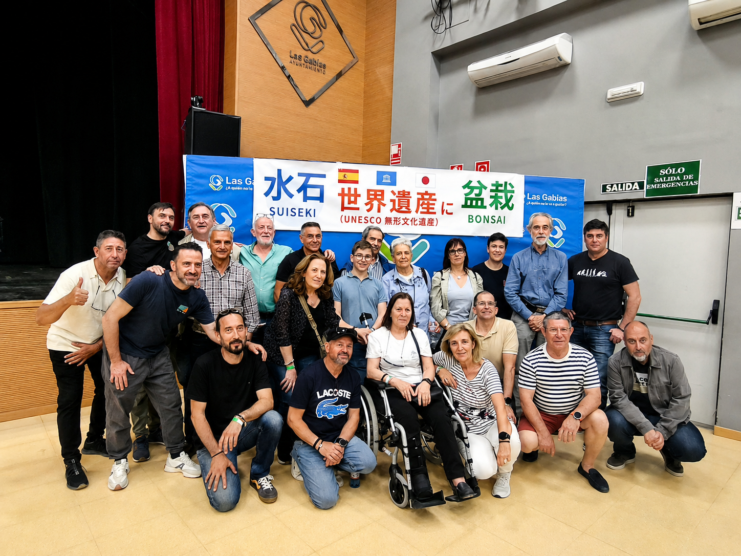 Foto de grupo de organizadores y participantes ante el cartel del IX Congreso Andaluz de Bonsái y II Jornadas Andaluzas de Suiseki de Las Gabias